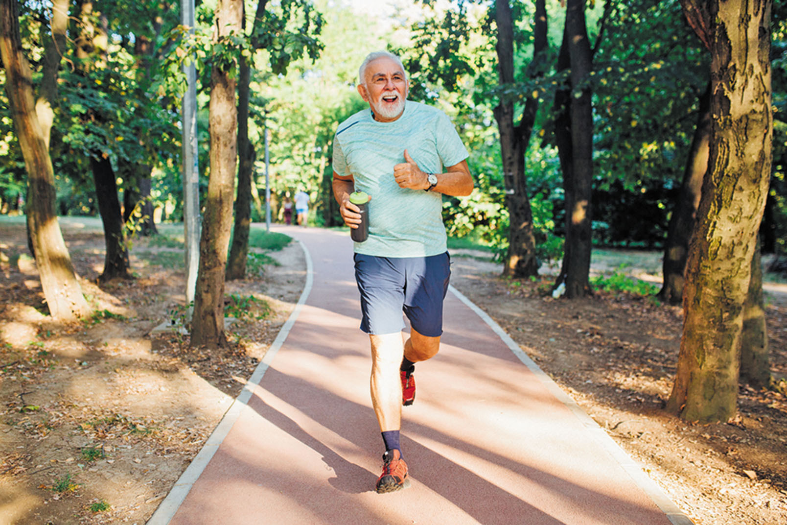 photo of a mature man jogging on a path in a park