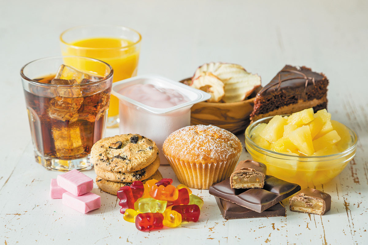 photo of an assortment of sweet foods, including baked goods, fruit juice, candy, and other sweetened food products