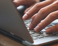 fingers at computer keyboard